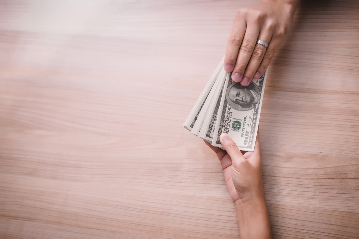 businessman-paying-money-united-states-dollar-usd-bills-2