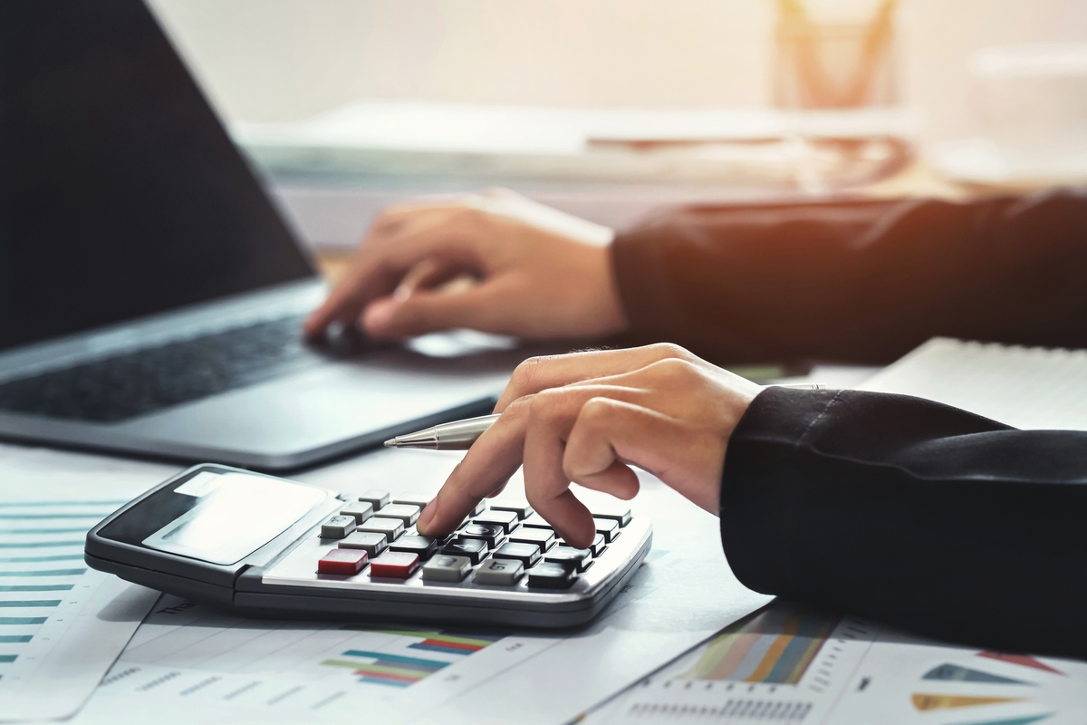 business accounting finance concept. accountant using calculator for calculate  with laptop working in office