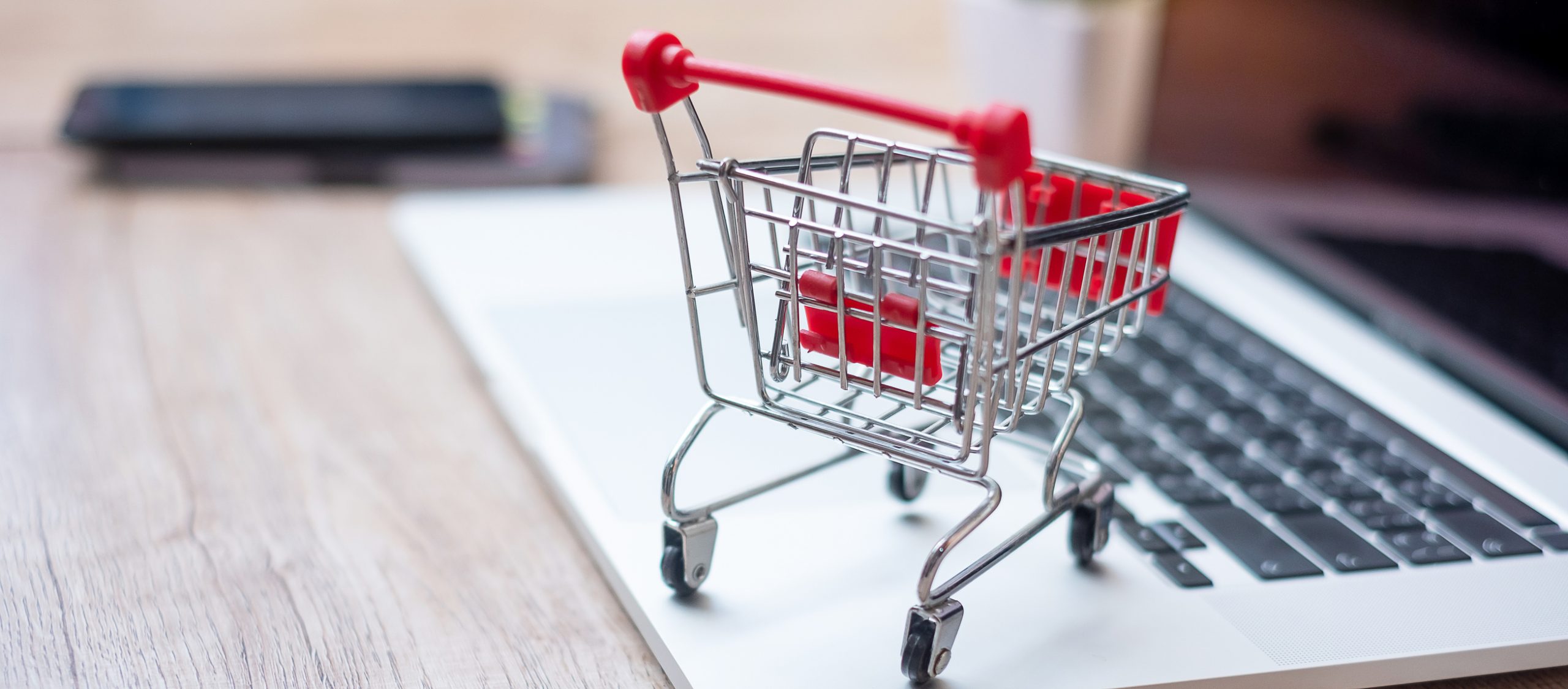 Shopping cart on laptop at home office. business, e-business, technology, e-commerce, digital banking and online payment concept
