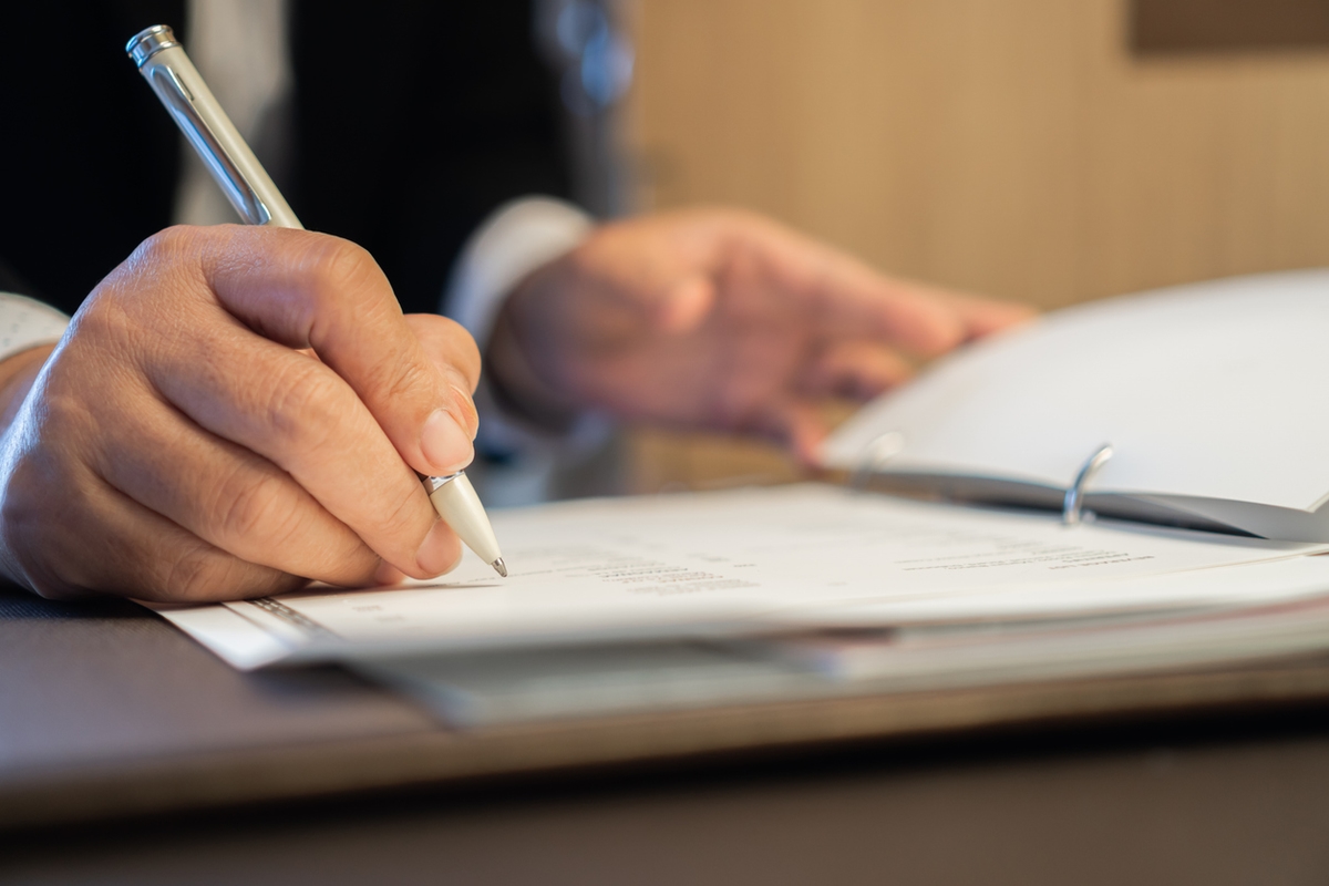Asian Business people Manager checking and signing applicant filling documents reports papers company application form or registering claim on desk office. Document Report and business busy Concept