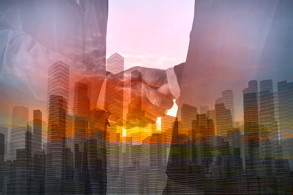 Double Exposure of Two Businessman shaking hand with City Building and Skyscraper as concept of Teamwork or Partnership business achievement.