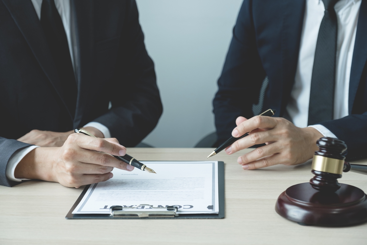 Lawyer hand holding pen and providing legal consult business dispute to the man