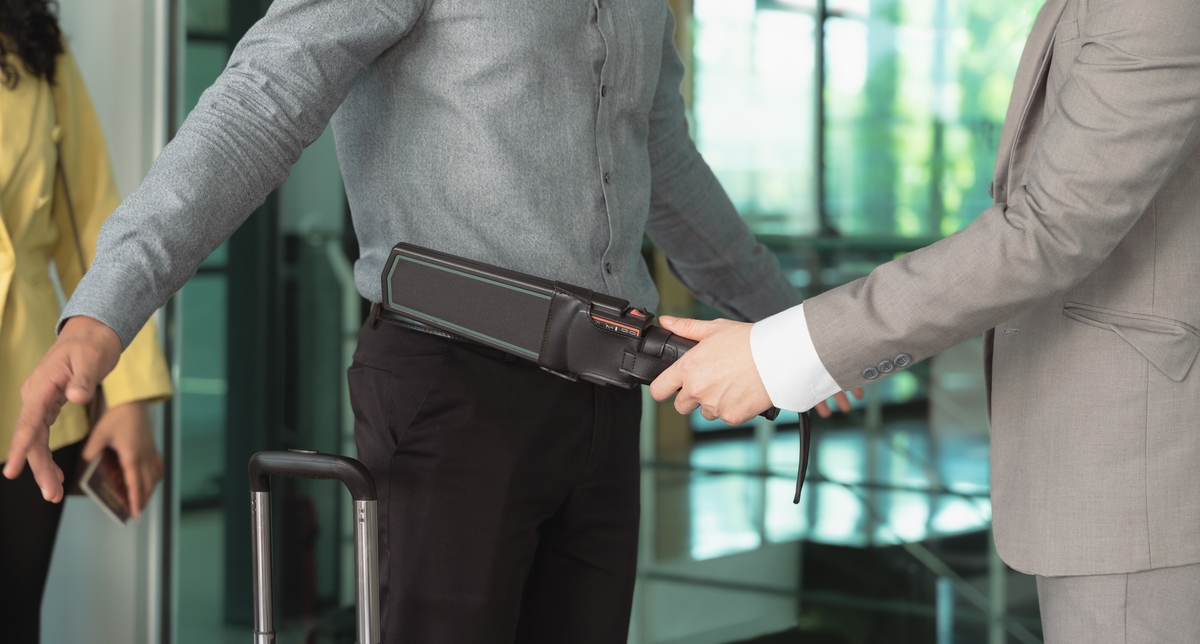 Security man check passenger at entrance in airport