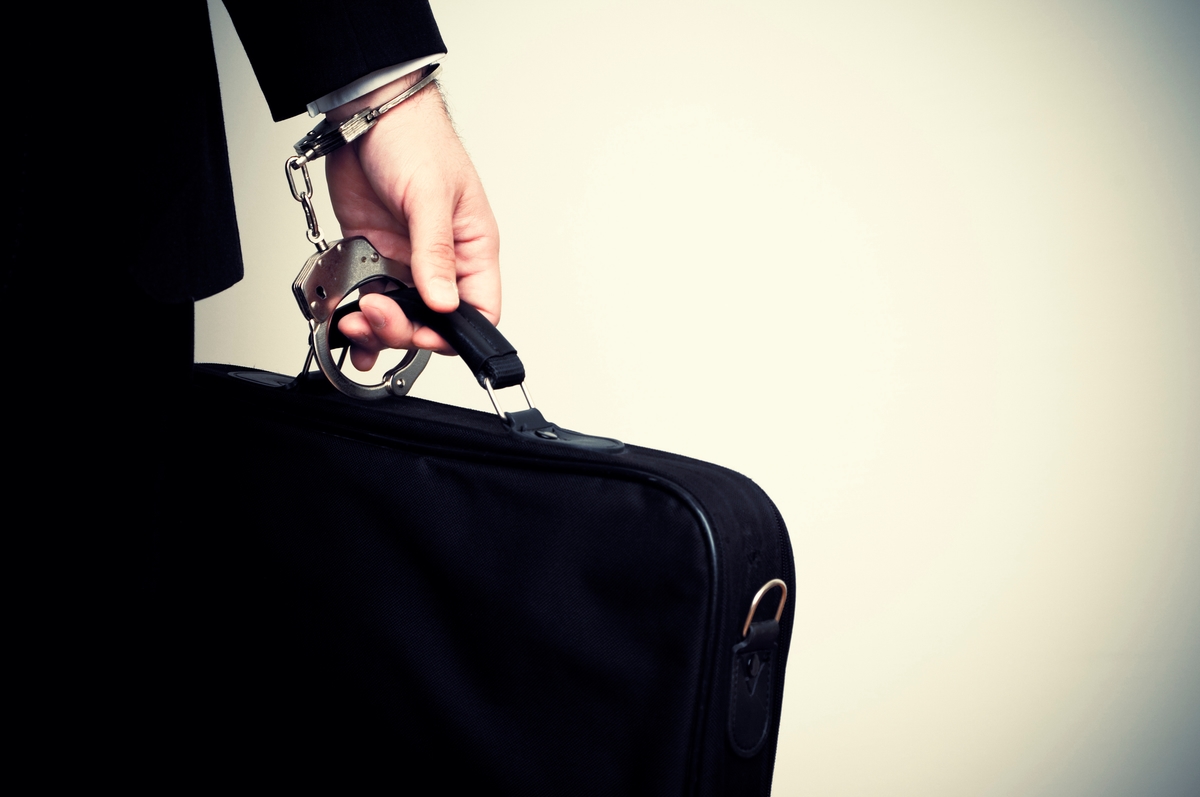 Businessman handcuffed to briefcase