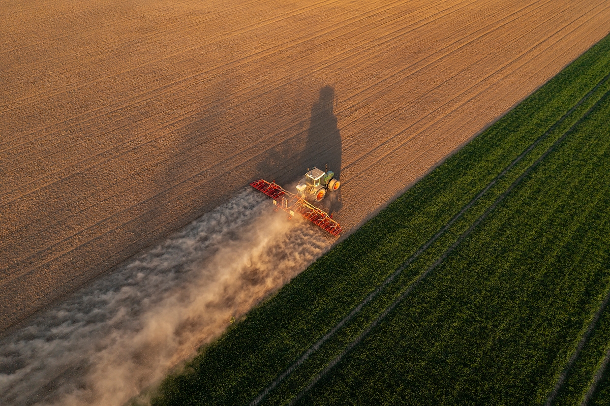 Tractor working in field, aerial view