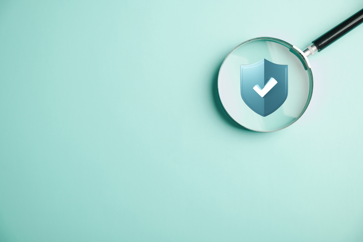 Magnifying glass highlights shield lock icon