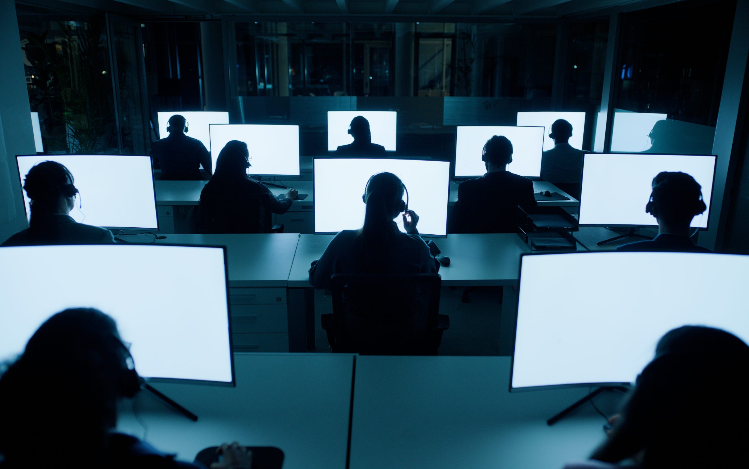 Computer, screen and mockup for call center worker, night shift and coworking for CRM software or UX for help desk employees. Customer service, sales or tech support with people in dark for telecom