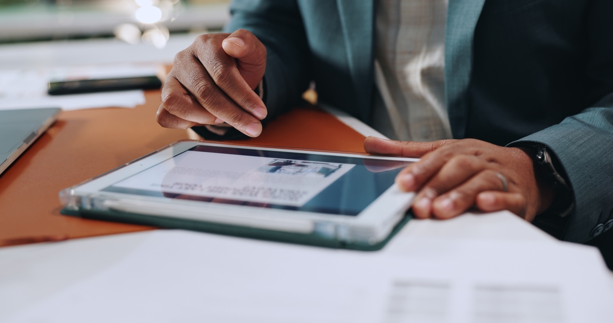 Businessman, hands and tablet with website, article and research for strategy and corporate news in office. Digital tech, project planning and scroll online for reading information, app with media