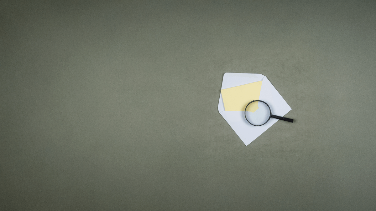 business-financial-concept-with-letter-envelope-magnifying-glass-grey-surface-flat-lay