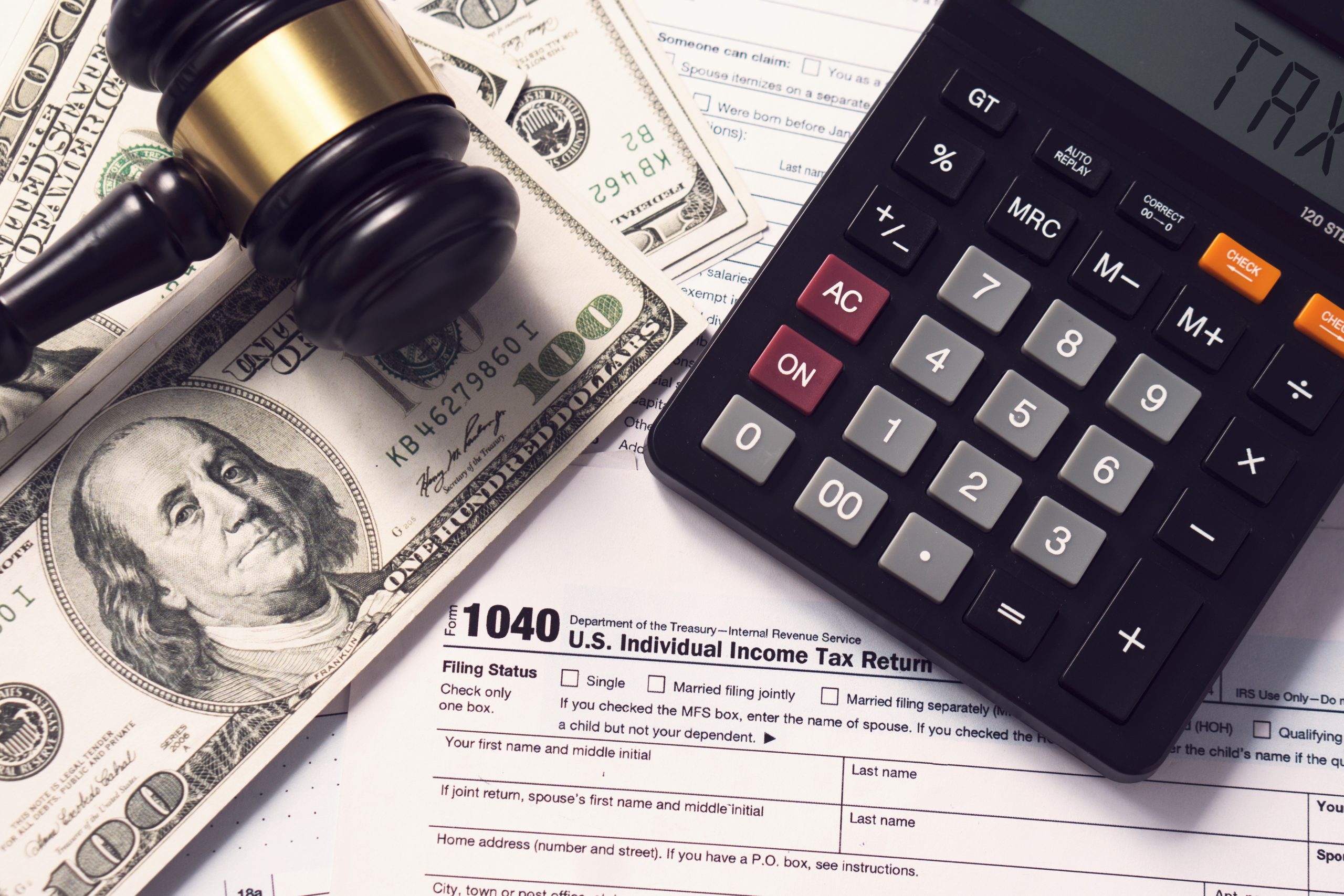 Tax concept.Calculator with taxes text with money on 1040 tax fo